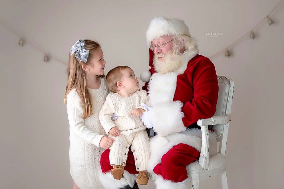 girl and baby sitting with Santa